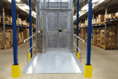 Magazijnlift die omlaag staat in een groot magazijn